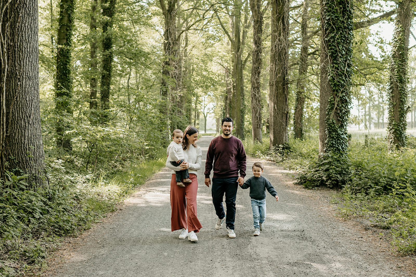 gezin aan het wandelen in het bos tijdens een fotoshoot